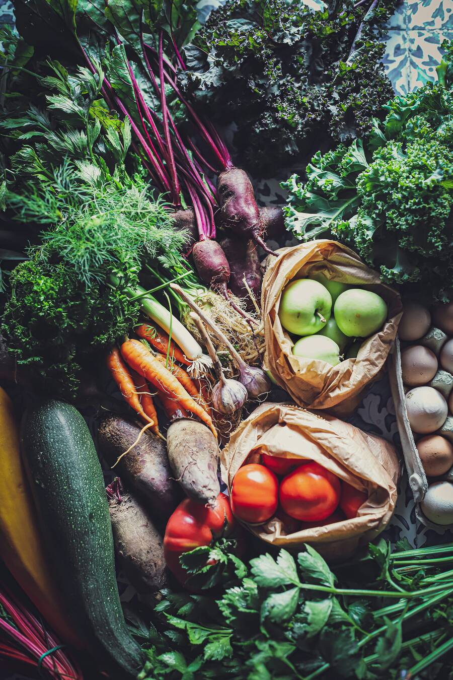 Fresh vegetables, apples and eggs spread on a table